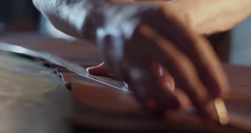 Man Cutting Leather with Ruler and Sharp Tool