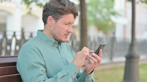 Man Using Mobile Phone Outdoors in City