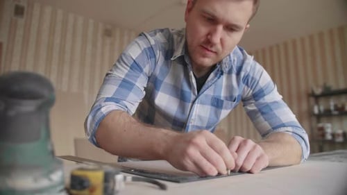 Man Marking Wood with Ruler and Pencil