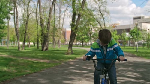 Preschooler Riding Bike through Park
