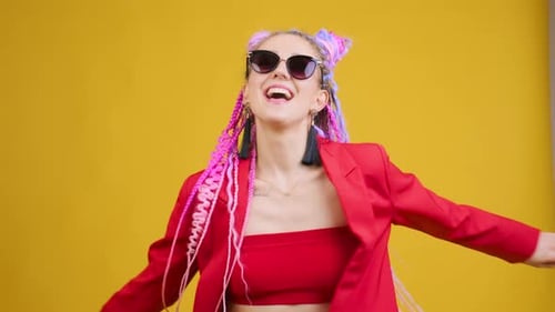 Funny Young Woman with Original Style of Hair Dancing in Studio Blue Background
