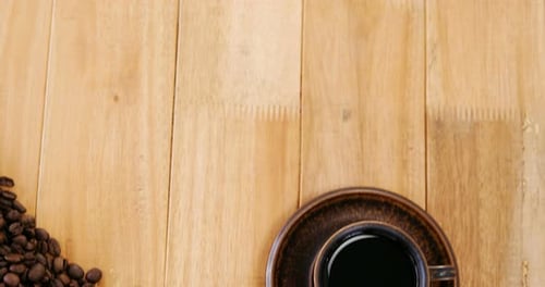 Dark Coffee with Beans on Wooden Table