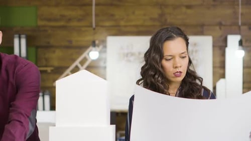 Architect and Businesswoman Working Together on a Building Model in the Office