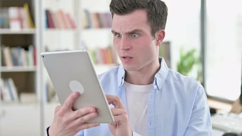 Man Surprised by Content on his Tablet