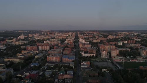 Aerial view of evening city at sunset, Cars drive on the roads, Summer warm evening 01