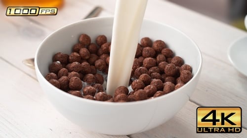 Milk Pouring on Chocolate Cereal Balls for Breakfast