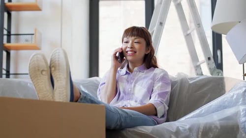 Cheerful Woman Relaxing with Phone Call During Home Renovation