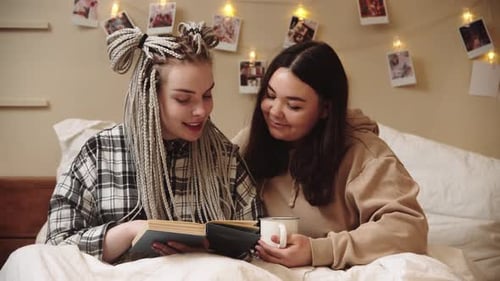 Two Friends Reading a Book in Bed