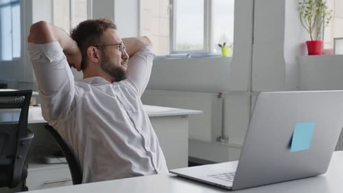 Sitting Man Puts His Hands Behind Head