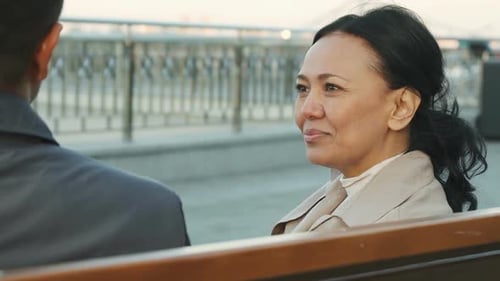 Woman Chatting with Man on Park Bench