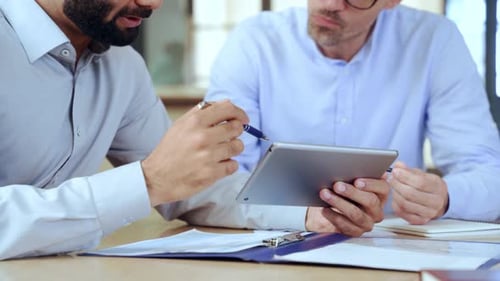 Two Men Discussing Business with Tablet in Workplace