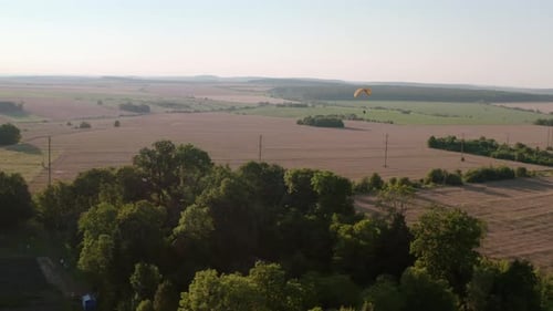 Paraglider Soaring Over Agricultural Fields Aerial Drone View