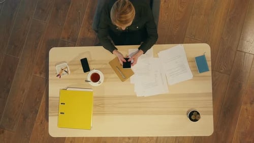 Confident Young Woman in Smart Casual Wear Holding Smart Phone and Texting Message in The Office