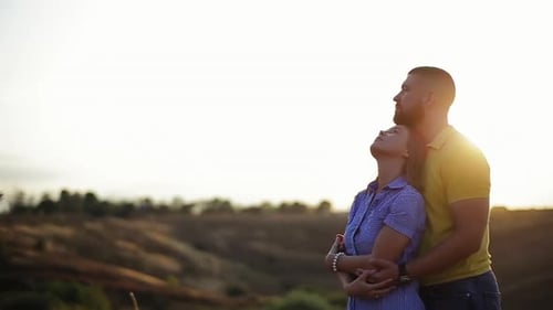 Romantic Young Couple in Love Story. Bearded Guy Hugging Girlfriend on Sunset in Deserted Field