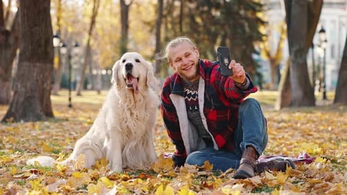 Man Takes Selfie with Dog in Fall Park