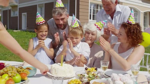 Family Celebrating a Child's Birthday Outdoors