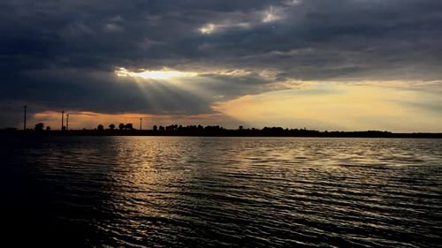 View from the boat to the setting sun on the shore of the lake.