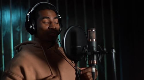 Man Sings Passionately Into Microphone in Recording Studio