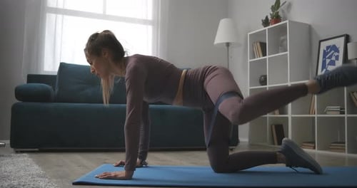 Woman Doing Leg Exercises at Home with Band