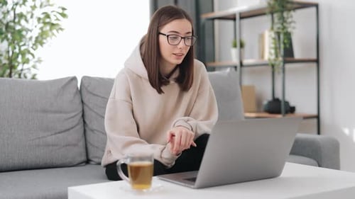 Young Woman Video Calling on Laptop at Home