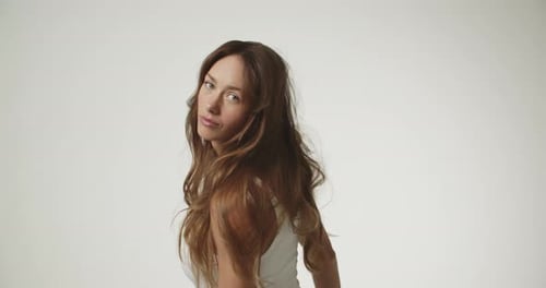 Woman Posing in Studio with Flowing Brown Hair