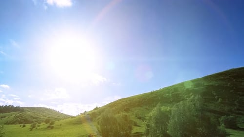 UHD Mountain Meadow Zeitraffer im Sommer. Bewegung von Wolken, Bäumen, grünem Gras und Sonnenstrahlen.