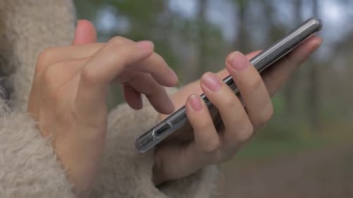Hands Using a Mobile Phone in Nature