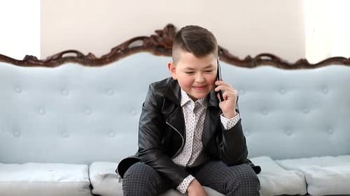 Young Boy Chatting Happily on Mobile Phone
