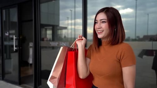 ralenti d'une femme heureuse avec des sacs à provisions