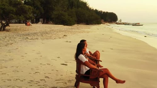 Girls happy and smiling on tranquil resort beach holiday by blue ocean with clean sand background of