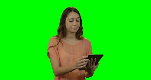 Woman Smiles Using Tablet on Green Screen