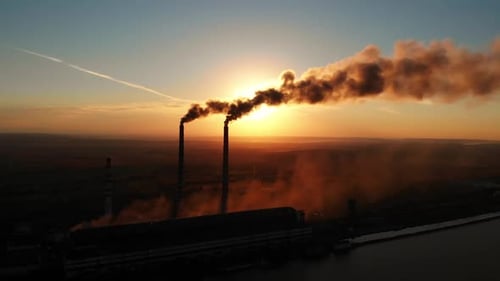 Drohnenaufnahme aus der Luft: Hohe Kaminrohre mit Schmutzrauch aus dem Kohlekraftwerk.