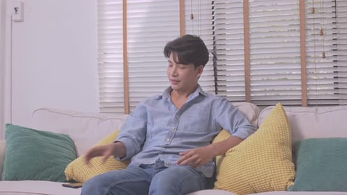 Man Answers Smartphone on Couch in Living Room