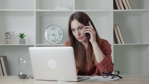 Woman Talking on Phone While Working at Desk