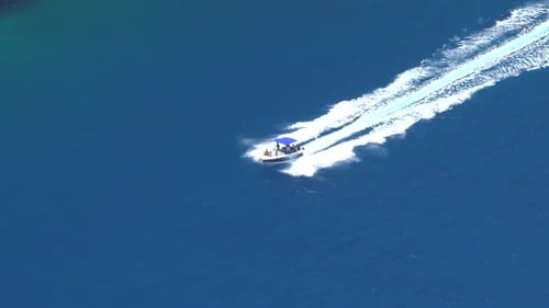As A Speed Boat Sails At Sea, It Leaves Behind A White Sparkling Trail