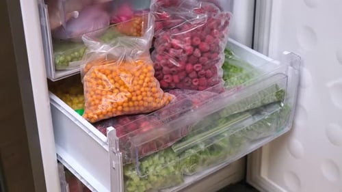 Freezer drawer full of frozen fruits and vegetables