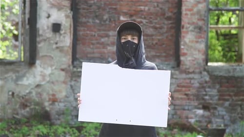 Woman Protesting On Street Covering Face With Bandana Holding Empty Cardboard
