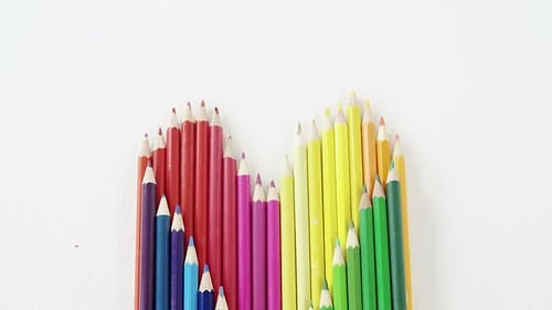 Rainbow Pencils Forming Heart on White Background