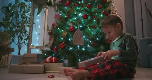 Excited Child Opening Christmas Present at Home