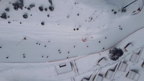 Luftaufnahme des Skigebiets mit Menschen, die den Hügel hinunter und den Lift hinauf fahren.