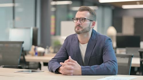 Middle Aged Businessman Sitting in Office and Waiting