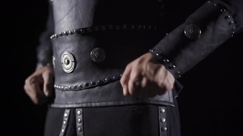 Dark Garment Decorated With Metal Studs Being Secured