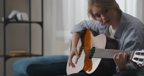 Woman Playing Acoustic Guitar at Home