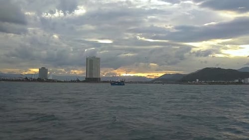 Atmospheric View of Clouds and Sunrise Skies Over Buildings and Mountains.