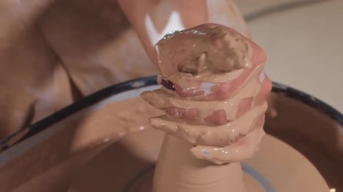 Hands Shaping Clay on Potter's Wheel Close Up