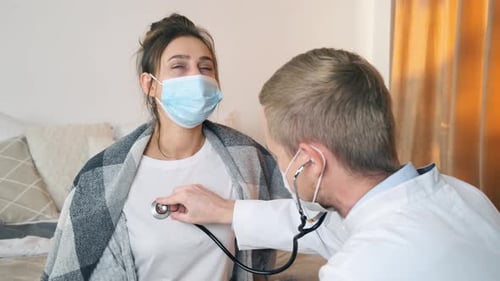Doctor Examines Young Woman with Stethoscope at Home