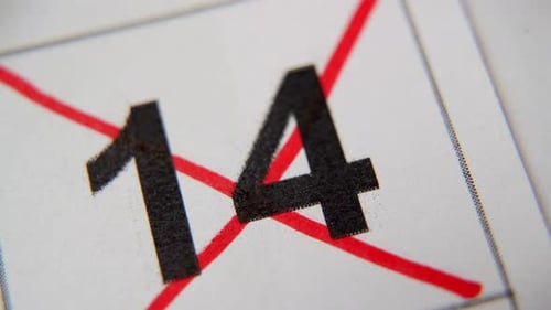 El número 14 del calendario está tachado con una cruz roja en una macro en una hoja blanca