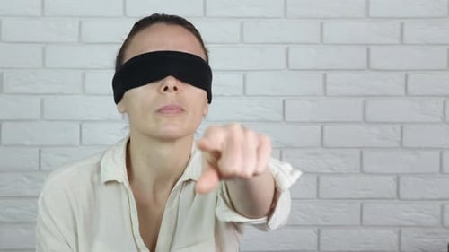 Blindfolded Woman Points Index Finger Towards Camera