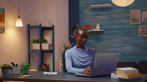 Young Woman Works at Laptop at Desk at Home