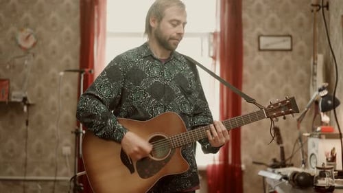 Man Plays Acoustic Guitar in Cozy Room